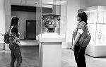 Two students looking at a vase encased in glass at the Met